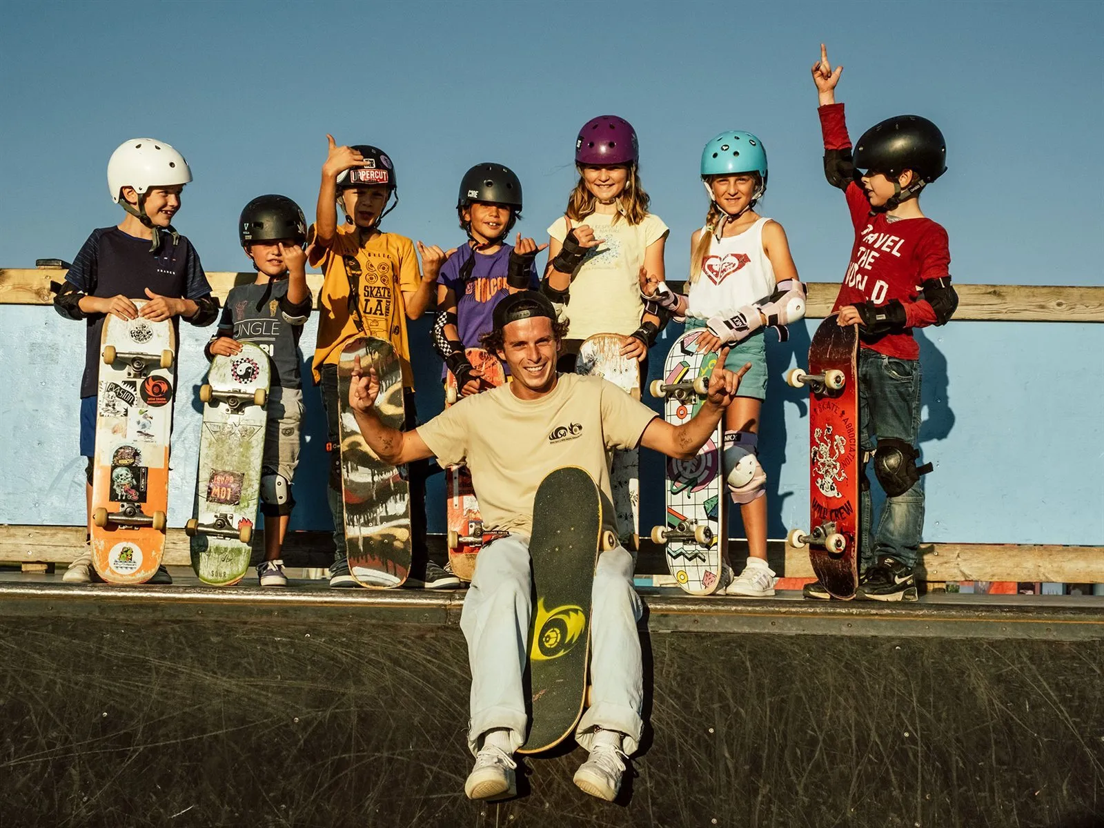 Skate instructor and group of children posing with their skateboards at WSA Guidel ramp