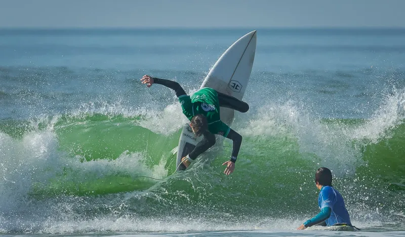 Surfer performing a cutback on a green wave during a WSA Guidel competition session