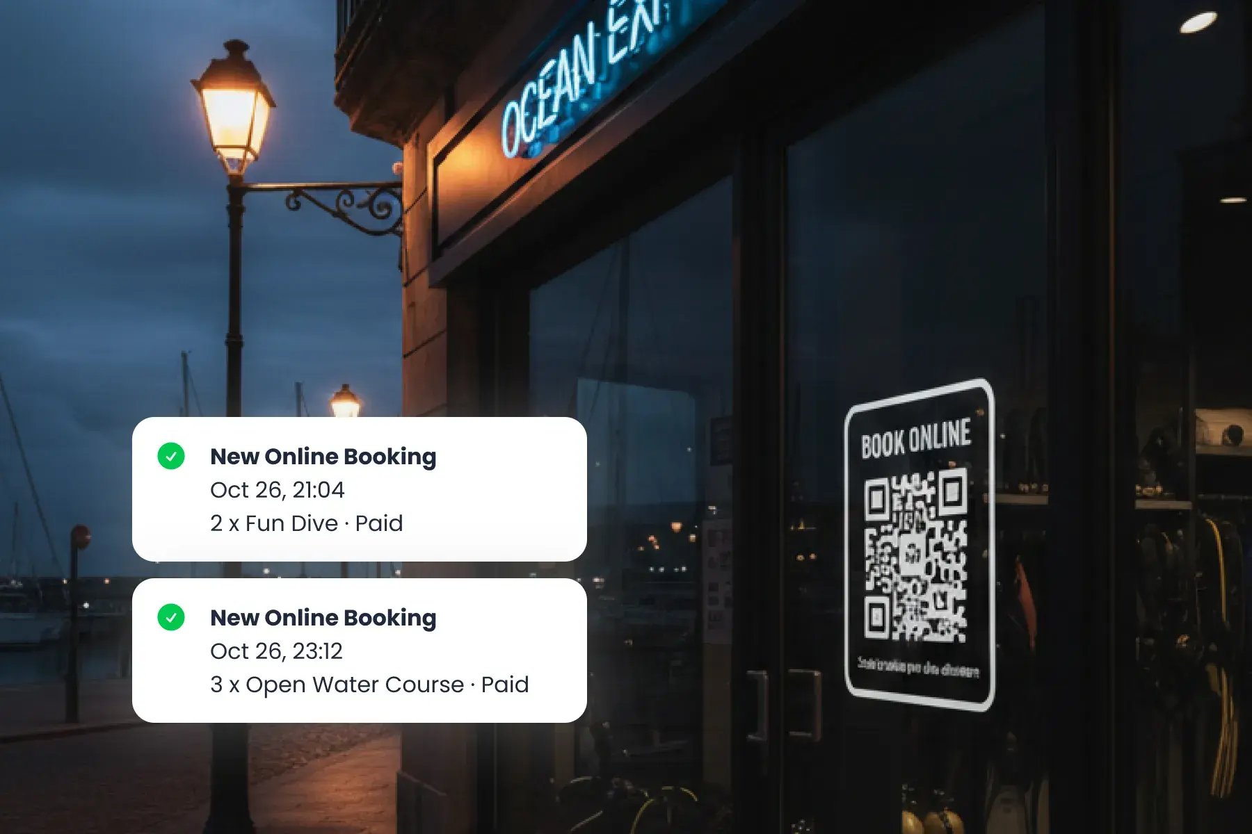 Dive center storefront at dusk with a digital booking QR code displayed, showing Bloowatch multichannel sales integration