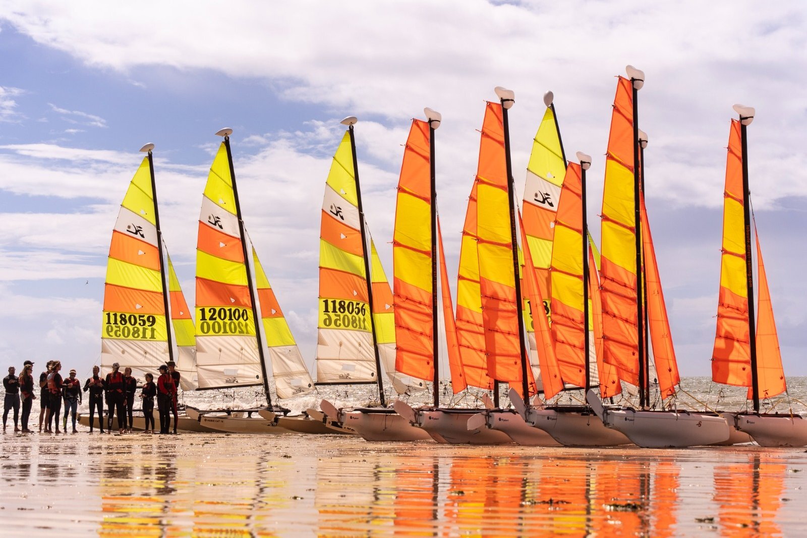 Flotta di catamarani riflessi sulla sabbia alla base nautica Yagga