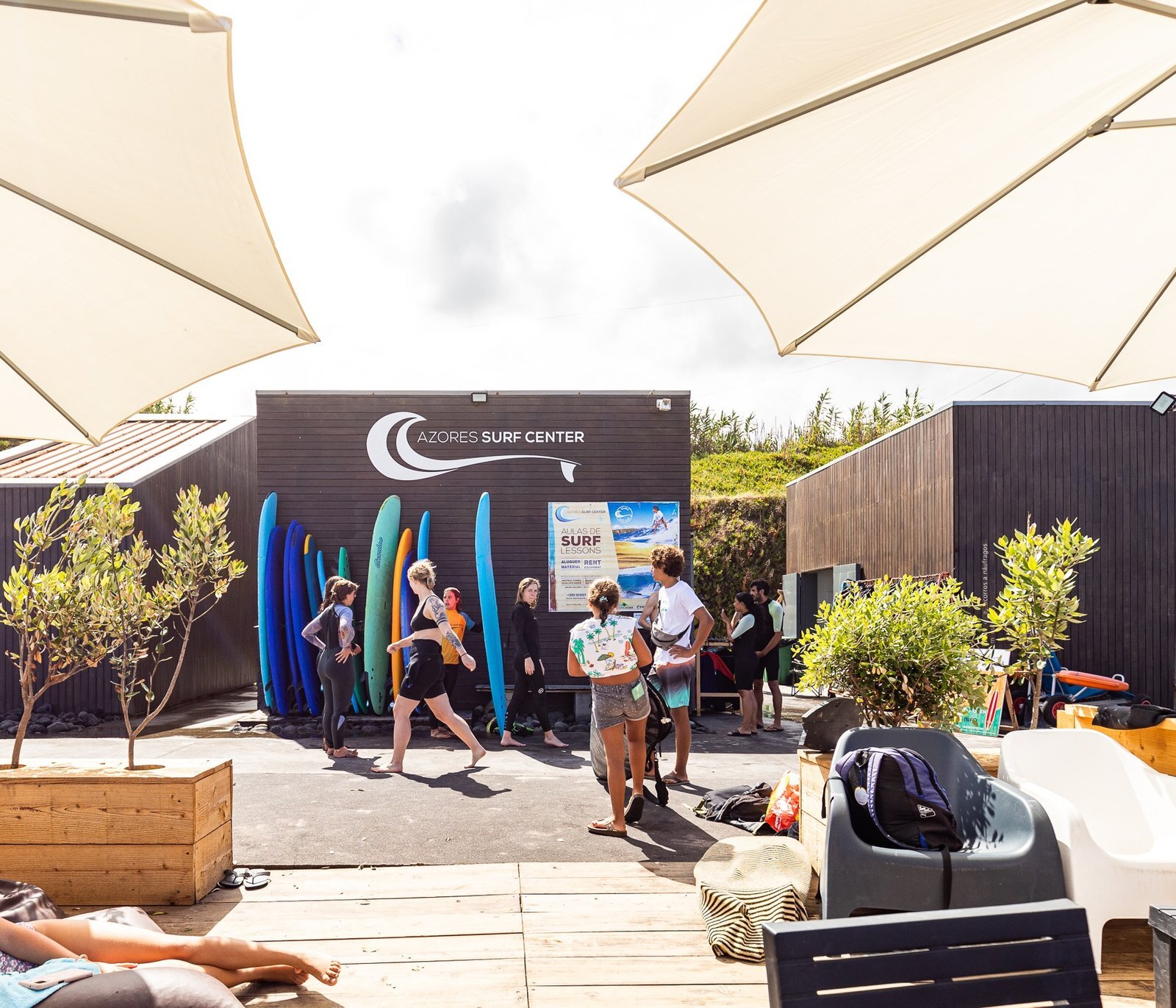 La base di Azores Surf Center con gli ombrelloni, una rastrelliera di tavole colorate e l’insegna del marchio