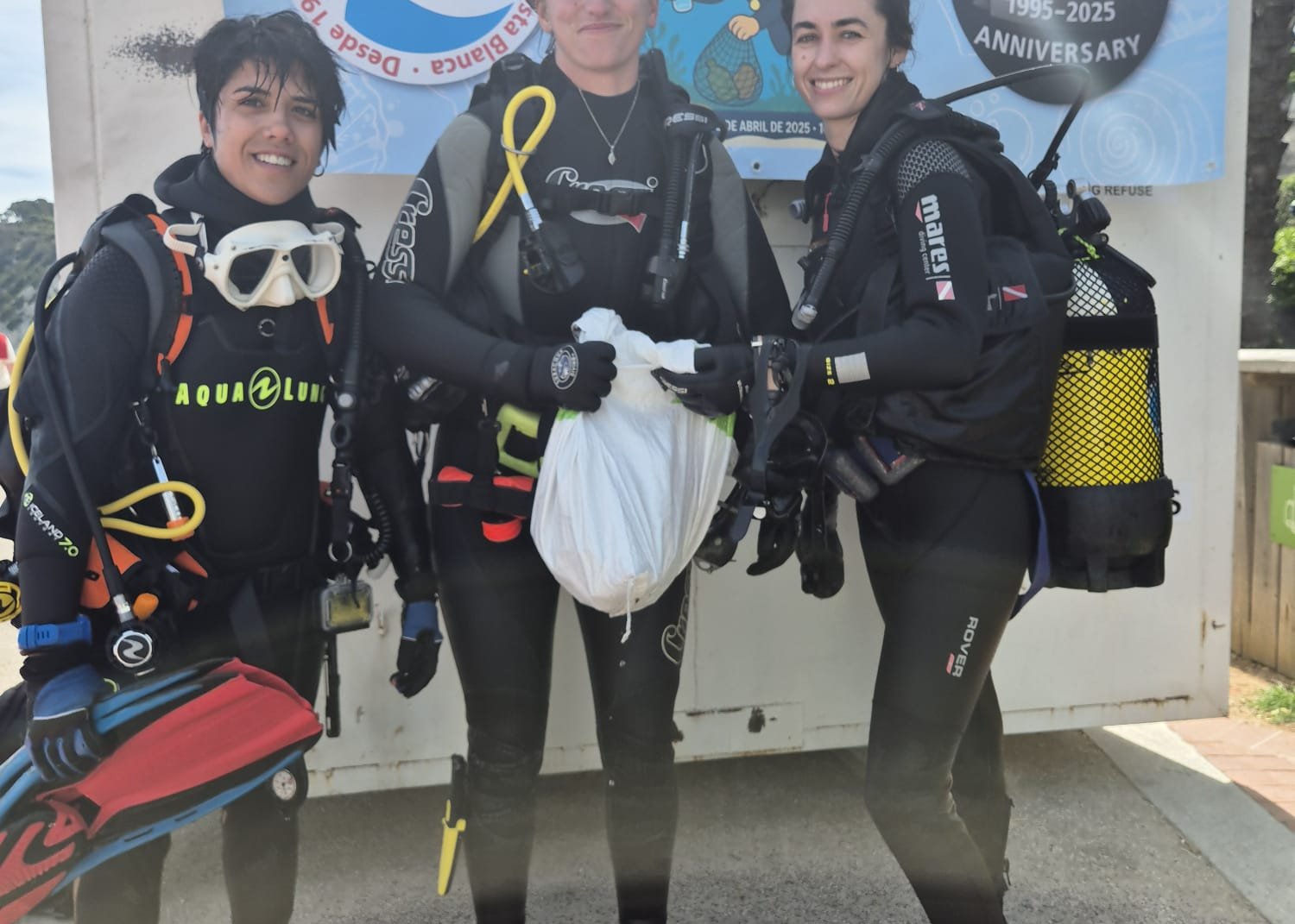 Tre subacquei di Buceo Cabo La Nao con un sacco di rifiuti raccolti durante una pulizia dei fondali a Jávea, per i 30 anni del centro