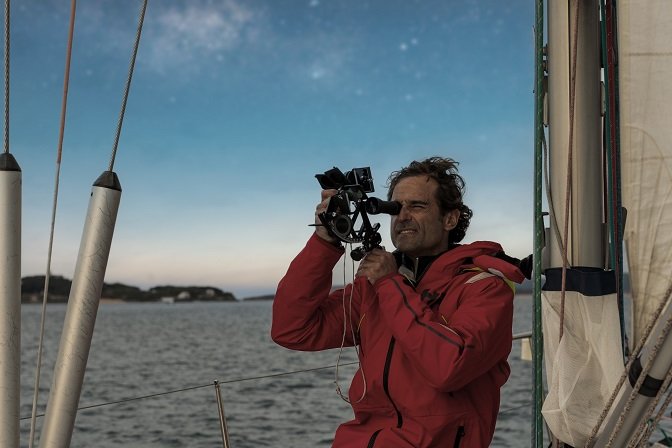 Un navigatore usa un sestante a prua di una barca a vela, di notte, sotto la Via Lattea, durante un’esperienza di astroturismo Cabo Mayor